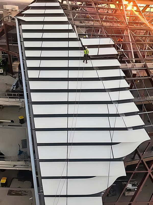 Aluminium extrusion and cladding replacement across a high-rise façade at dusk